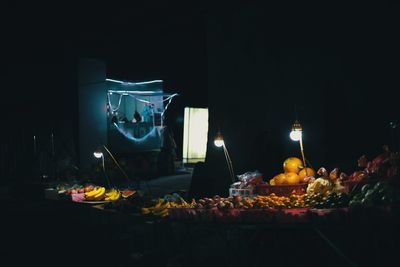 Illuminated fruits on table at night