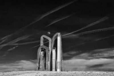 Low angle view of built structure on field against sky at dusk