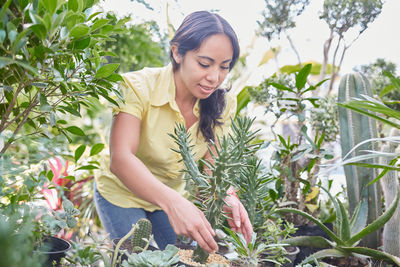 Beautiful young woman looking at plants