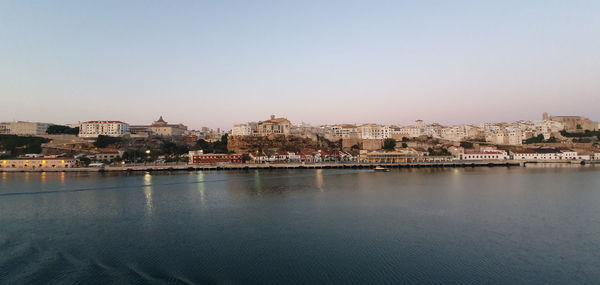 River and buildings against clear sky