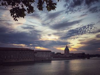 Buildings against cloudy sky at sunset