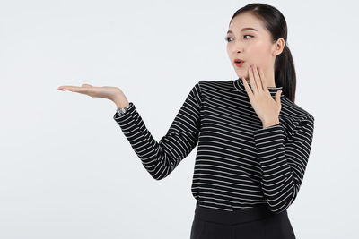 Young woman looking away against white background