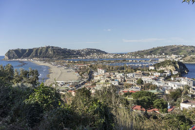 Aerial view of town by buildings in city against sky