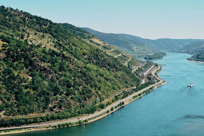 Aerial view of lake by road and hill