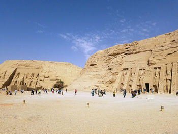 People in front of old ruin building against sky