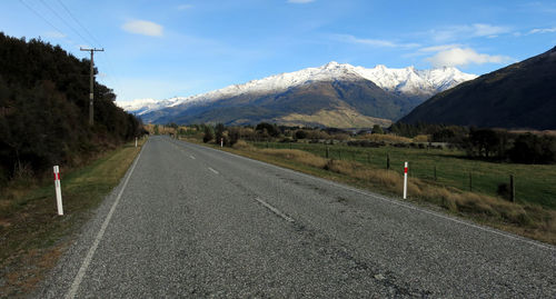 Empty road leading towards mountain during winter