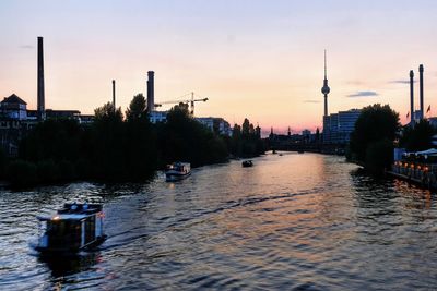 Boats in river at sunset