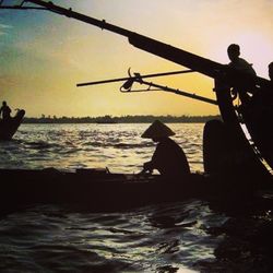 Boats in sea at sunset