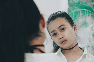 Close-up of young woman reflecting on mirror