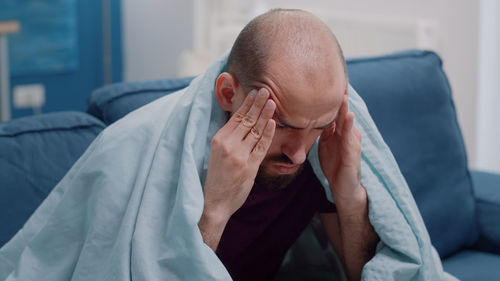 Depressed man sitting on sofa