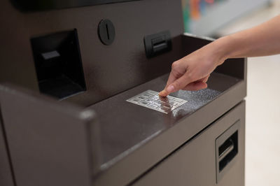 Cropped hand of person washing machine