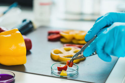 Cropped hands of scientist experimenting on bell peppers