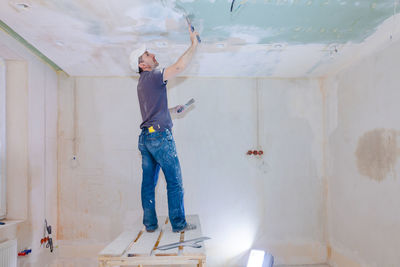 Full length of man standing against wall