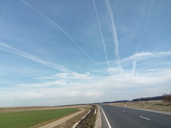 Road amidst landscape against blue sky