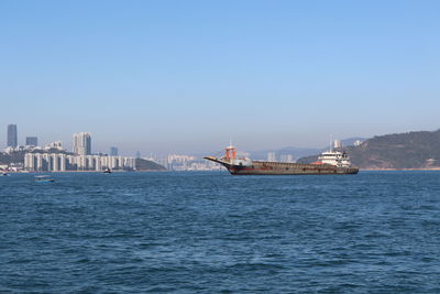 Scenic view of sea and buildings against clear sky