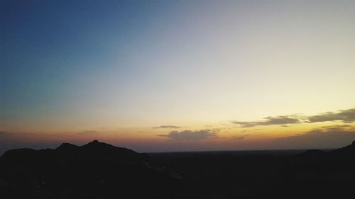 Scenic view of silhouette mountains against sky during sunset