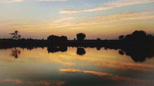 Scenic view of lake against orange sky