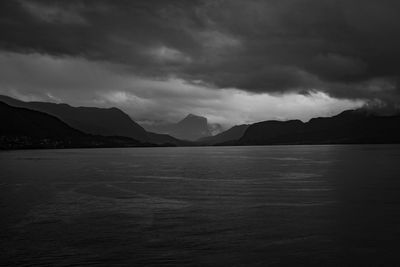 Scenic view of sea and mountains against sky