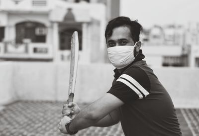 Portrait of young man standing outdoors wearing protective gear during quarantine time. 