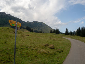 Road amidst green landscape against sky