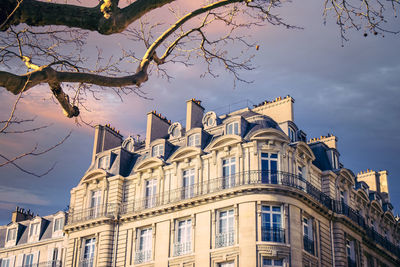 Low angle view of buildings against cloudy sky