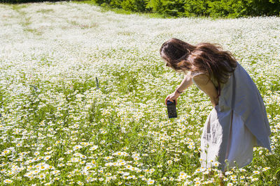 Women with dress take photo in field of daisy flowers, travel theme