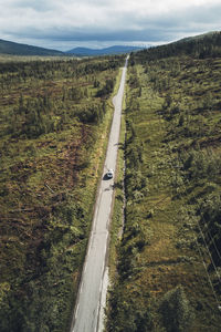 Road leading towards landscape against sky