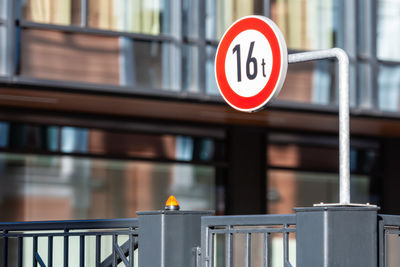 Close-up of warning sign on railing against building