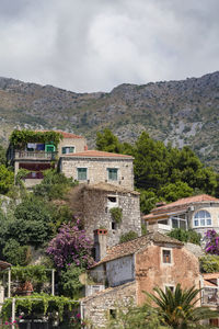 Built structure against trees and mountains against sky