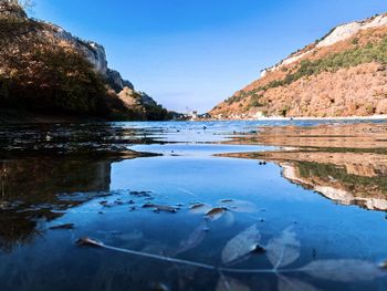 Scenic view of sea and mountains against clear blue sky