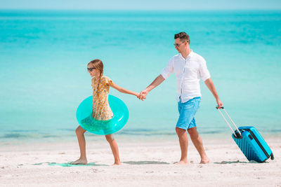 Father and daughter walking on beach