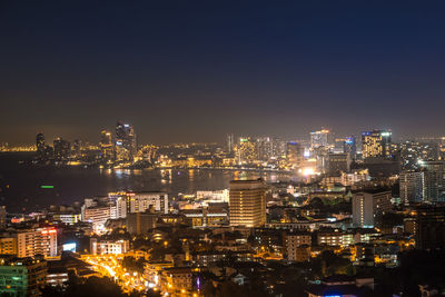 Illuminated cityscape against clear sky at night