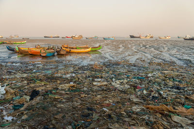 Boats moored on beach against clear sky