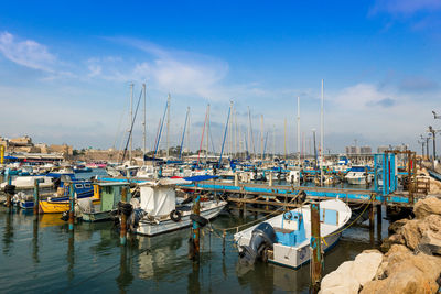 Boats moored at harbor against sky