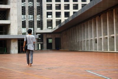 Rear view of boy walking in building