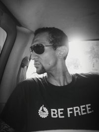 Close-up of mid adult man against car