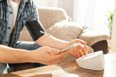 Midsection of woman using mobile phone on bed at home