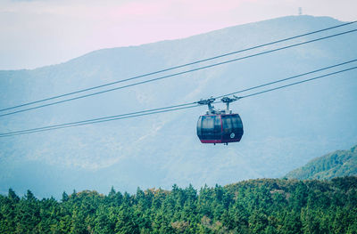 Low angle view of overhead cable car against sky