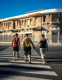 Full length of people walking on road in city