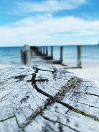 Close-up of wooden post on pier over sea against sky