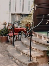 Empty chairs and tables in yard against building