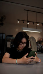 Young woman using mobile phone at home