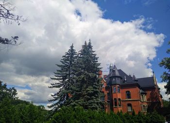 Low angle view of trees and buildings against sky