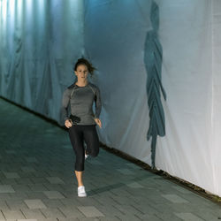 Woman jogging at night by the city river