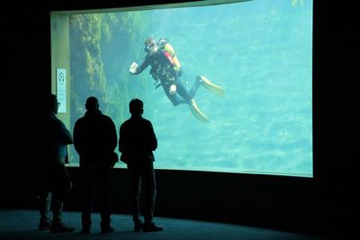 Men swimming in aquarium