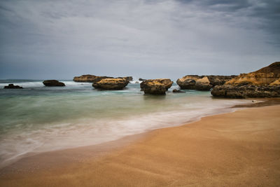 Rocks on beach against sky