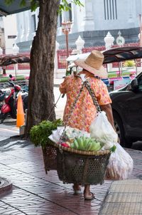 Rear view of woman holding ice cream cone on street