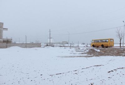 Snow covered field against clear sky