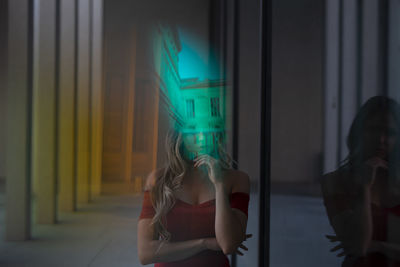 Digital composite image of woman standing in illuminated room