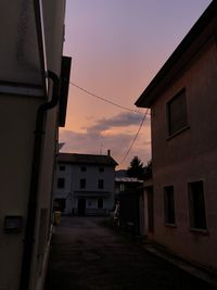 Street amidst buildings in town during sunset